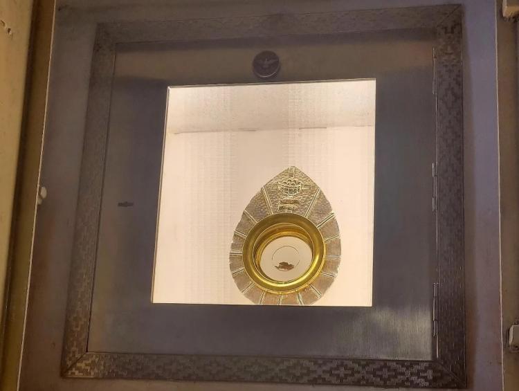 The Eucharistic sign displayed in a framed monstrance-like case at Santa Maria parish in Buenos Aires.
